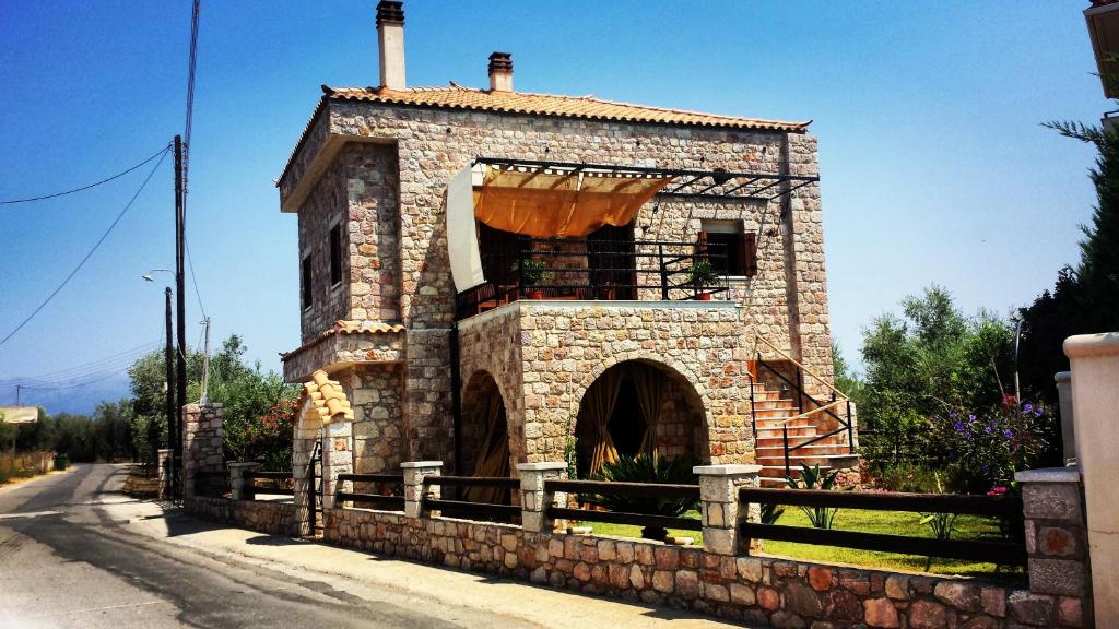 a stone building with a balcony on a street at Niko's Stone Guest House in Plitra