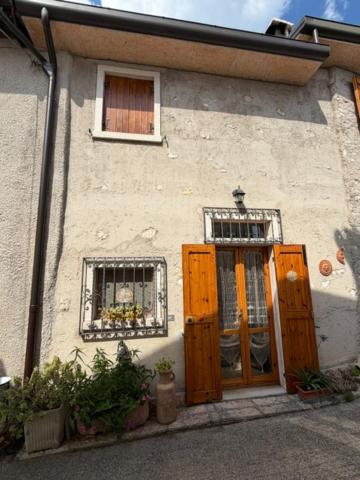 a building with wooden doors and windows and a window at Casa Sandrina in Caprino Veronese