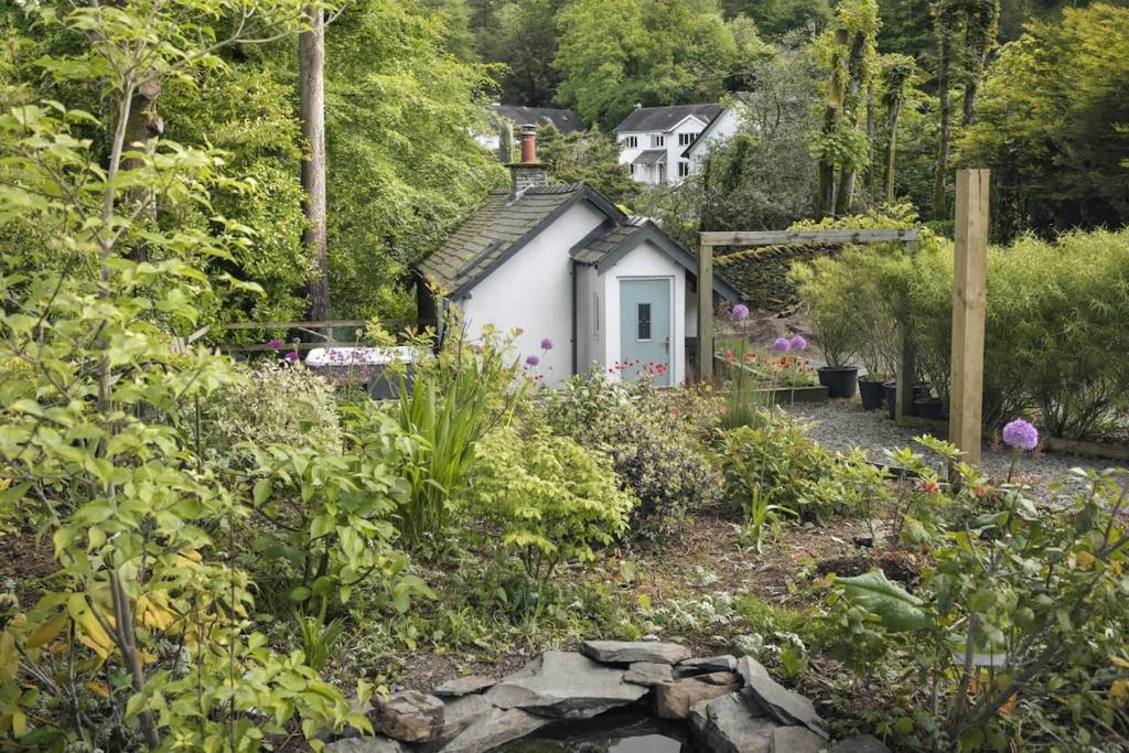 a small cottage in the middle of a garden at The Cosy Cottage - Ridgestone in Bowness-on-Windermere