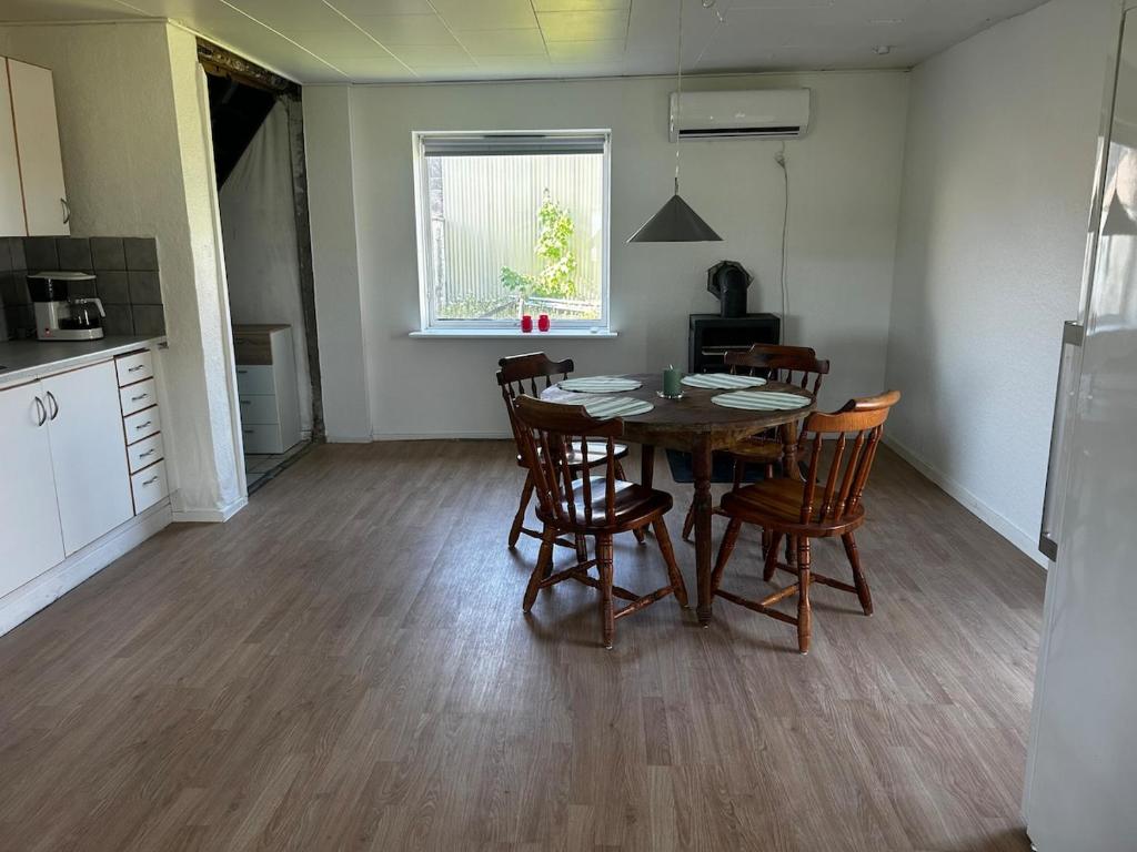a kitchen and dining room with a table and chairs at Small house in rural surroundings in Gelstrup