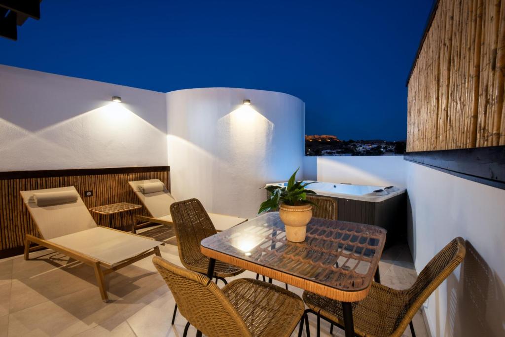 a patio with a table and chairs on a balcony at ARCH Luxury Suites in Archangelos