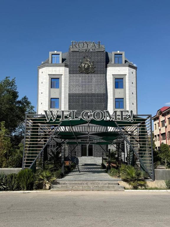 a building with a welcome sign in front of it at Royal Hotel Navoi in Navoi