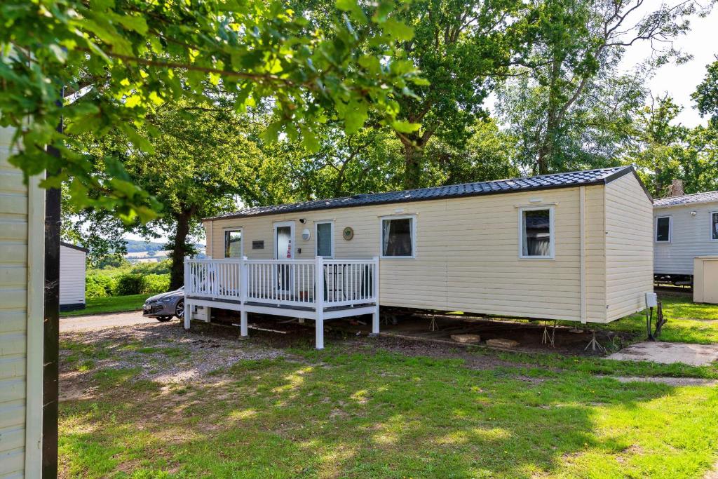 a white tiny house with a porch in a yard at Finest Retreats - Seascape in Porchfield