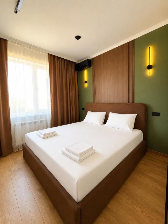 a bedroom with a large bed with white sheets at Гостиница Балхаш in Balqash