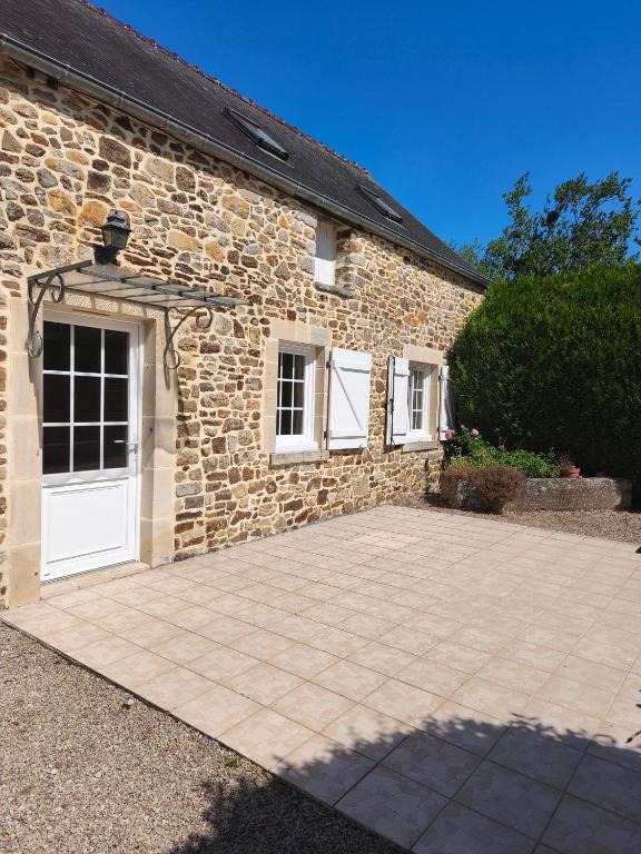a brick building with a white door and a driveway at Gîte Mouchel in Le Vrétot