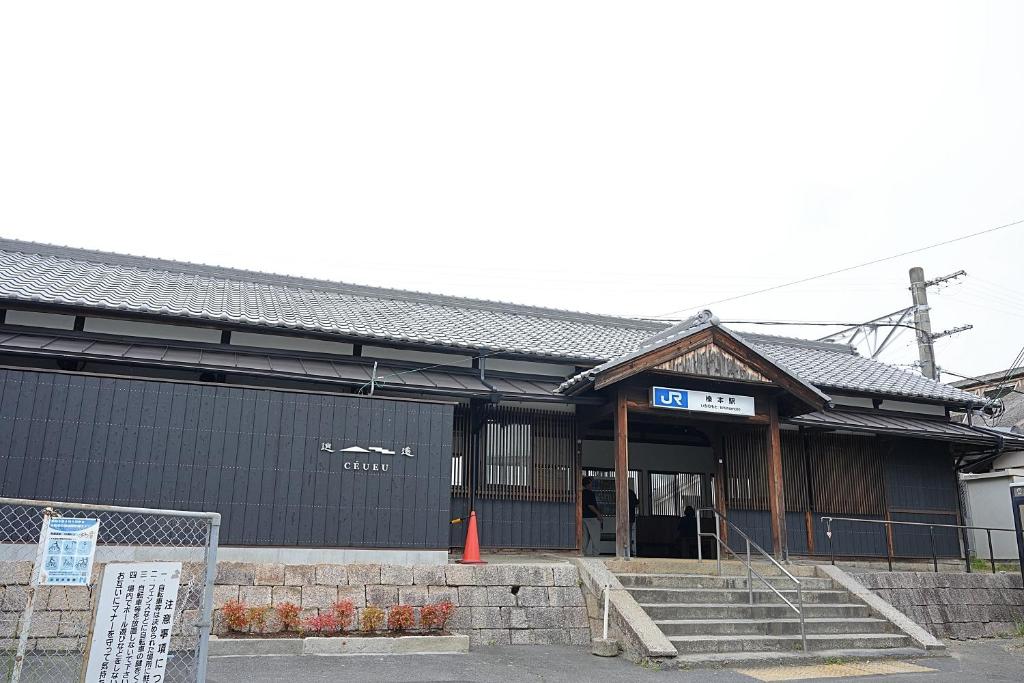 a building with a sign in front of it at ceueu 櫟本駅 in Tenri