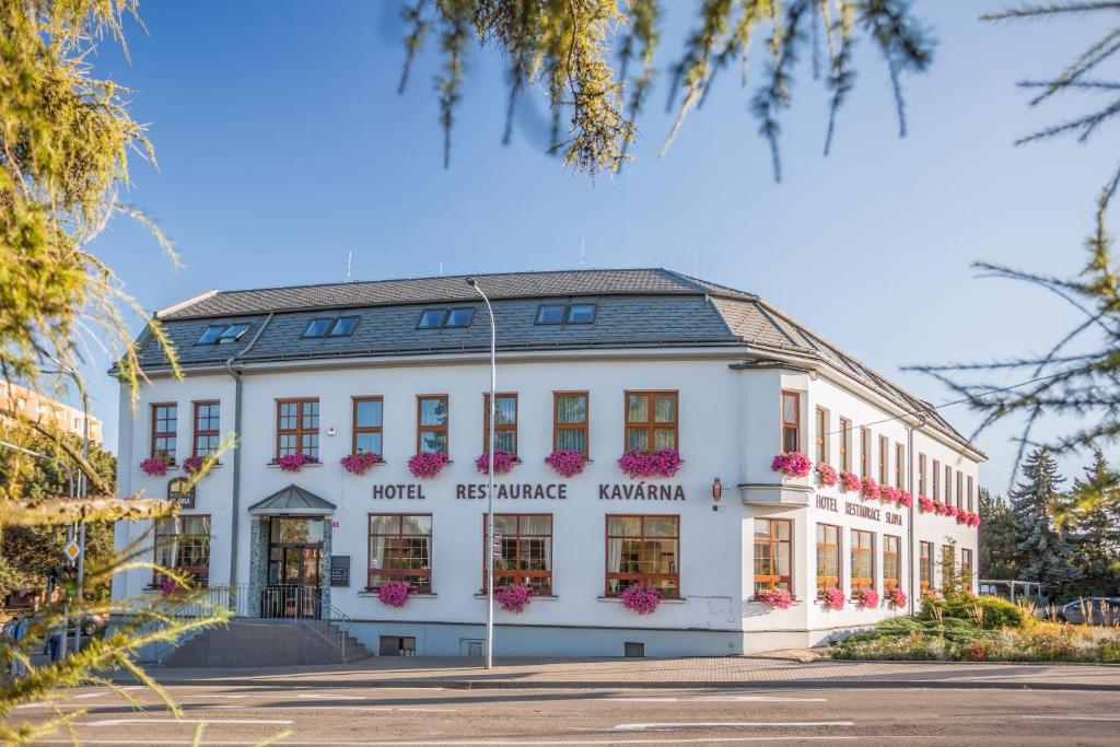a white building with flowers on the windows at Hotel Slavia in Boskovice