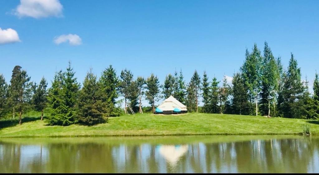 a tent on a hill next to a lake at GLaMPLIFE,tünni ja suitsusaunaga in Kasaritsa