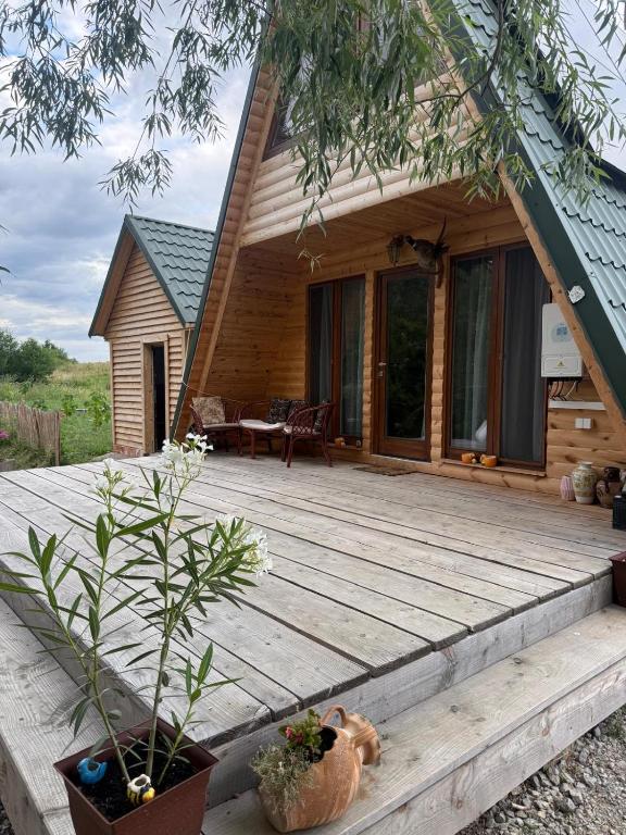 a wooden deck in front of a cabin at Cabanele din RÂTUL FLORILOR in Hotar
