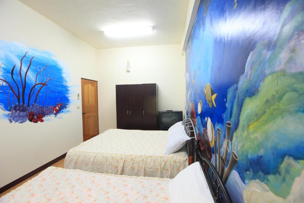 花蓮市的住宿－福杯滿溢民宿，一间卧室设有两张床,墙上挂着一幅画