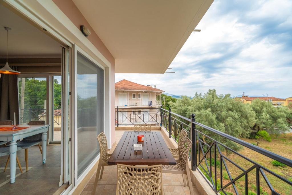 a balcony with a wooden table and a table at Paradise Sea View Apartments in Lygia