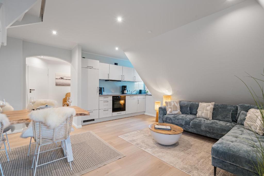 a living room with a couch and a table at Nordseebude Deichtraum in Sankt Peter-Ording