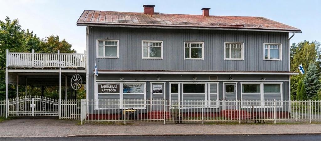 a gray house with a white fence in front of it at Kiinteistö Hetekka in Kouvola