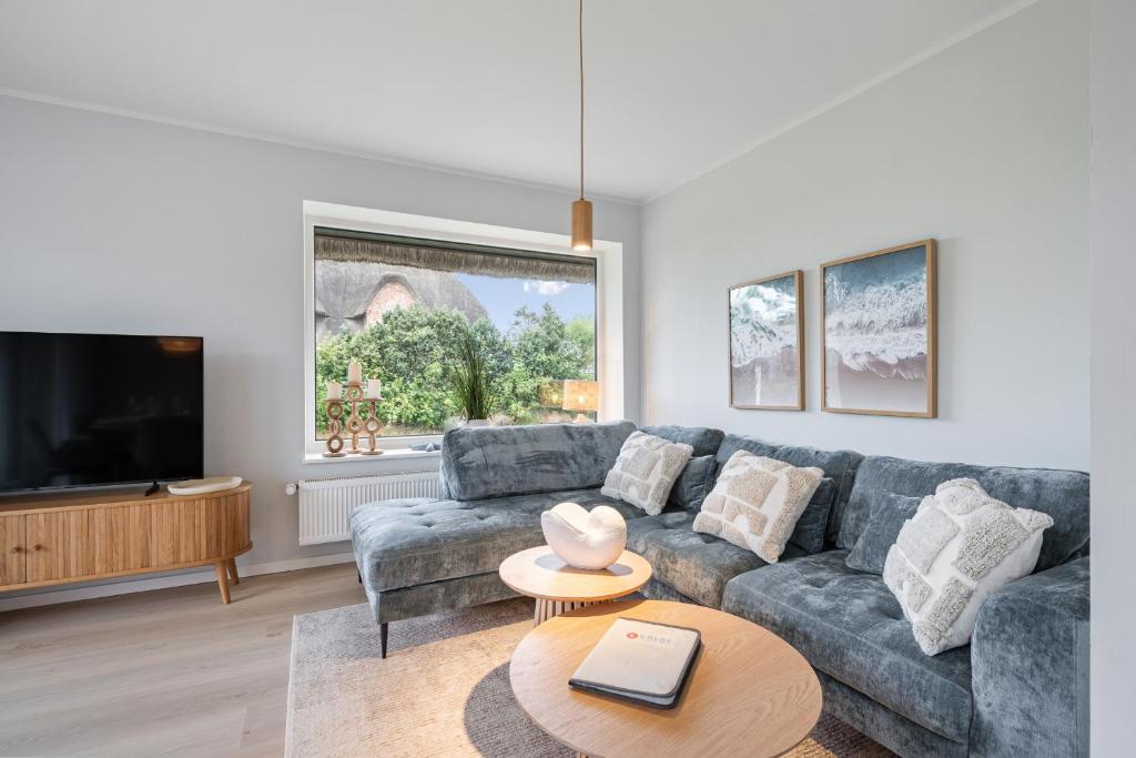 a living room with a couch and a tv at Nordseebude Strandnest in Sankt Peter-Ording
