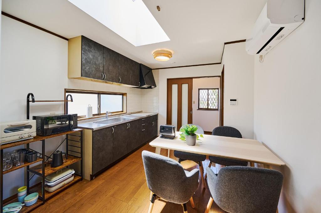 a kitchen with a table and chairs in a room at Kokonimo Yotsukaido in Yotsukaidō