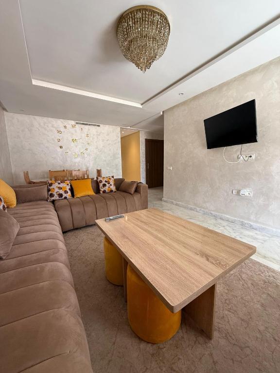 a living room with a couch and a wooden table at Blue water house in Dar Bouazza