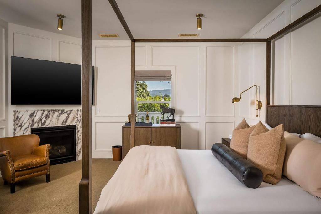 a bedroom with a bed and a fireplace and a television at Polo House and Bungalows in Santa Ynez