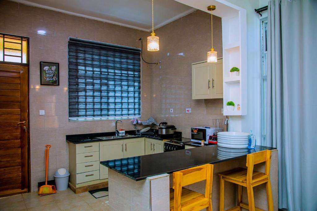 a kitchen with a counter and a stove top oven at ExtraMile Apartments - 2BR in Dodoma