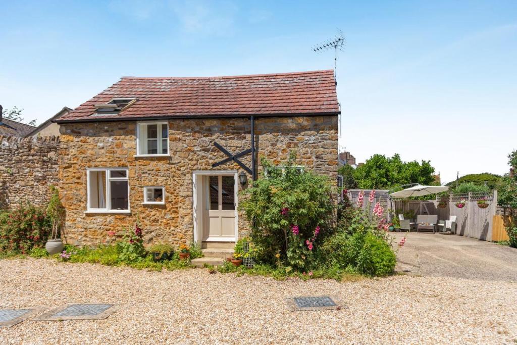 a small stone house with a garden in front of it at 2 Bed in Bridport oc-dc110 in Chideock