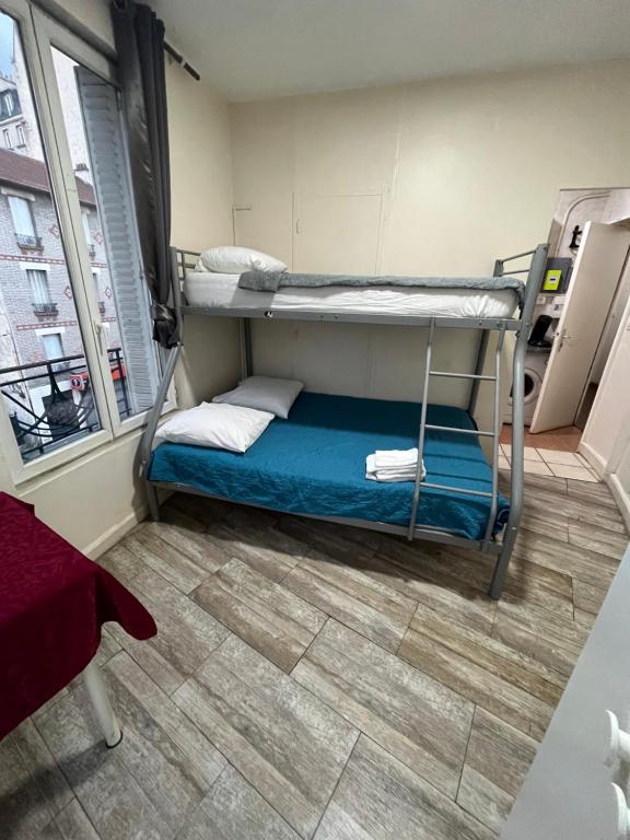 a small room with two bunk beds in it at myappart - colombes in Colombes