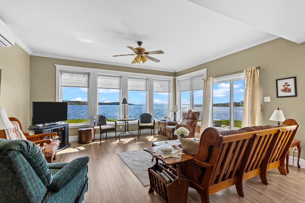 a living room with a view of the ocean at Westward Oceanfront Sunsets over Trinity Bay in Hearts Delight