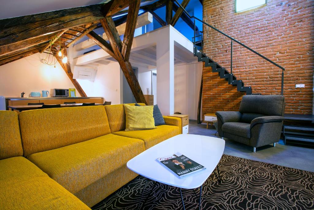 a living room with a couch and a table at Apartments At The Blue Duckling in Prague