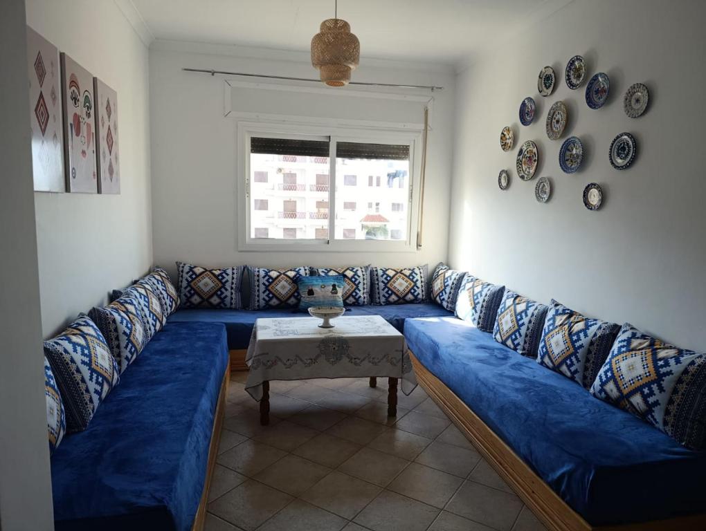 a blue couch in a living room with a table at Appartement à oued laou mekkad in Oued Laou