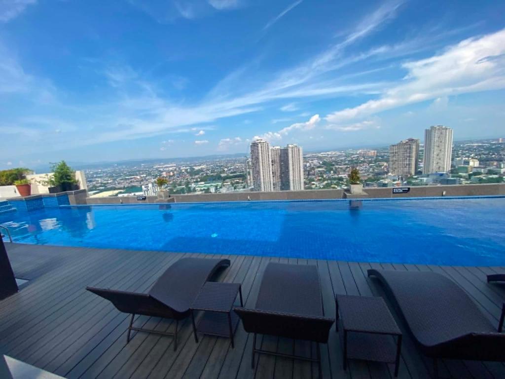 a large swimming pool on the roof of a building at MyHappyPlace Elements in Manila
