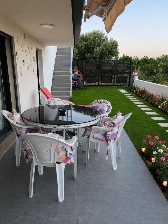 a patio with a table and chairs and a yard at Villa Tego in Çeşme