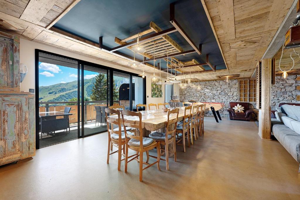 a dining room with a long table and chairs at Lodge Six De Savoie in La Toussuire