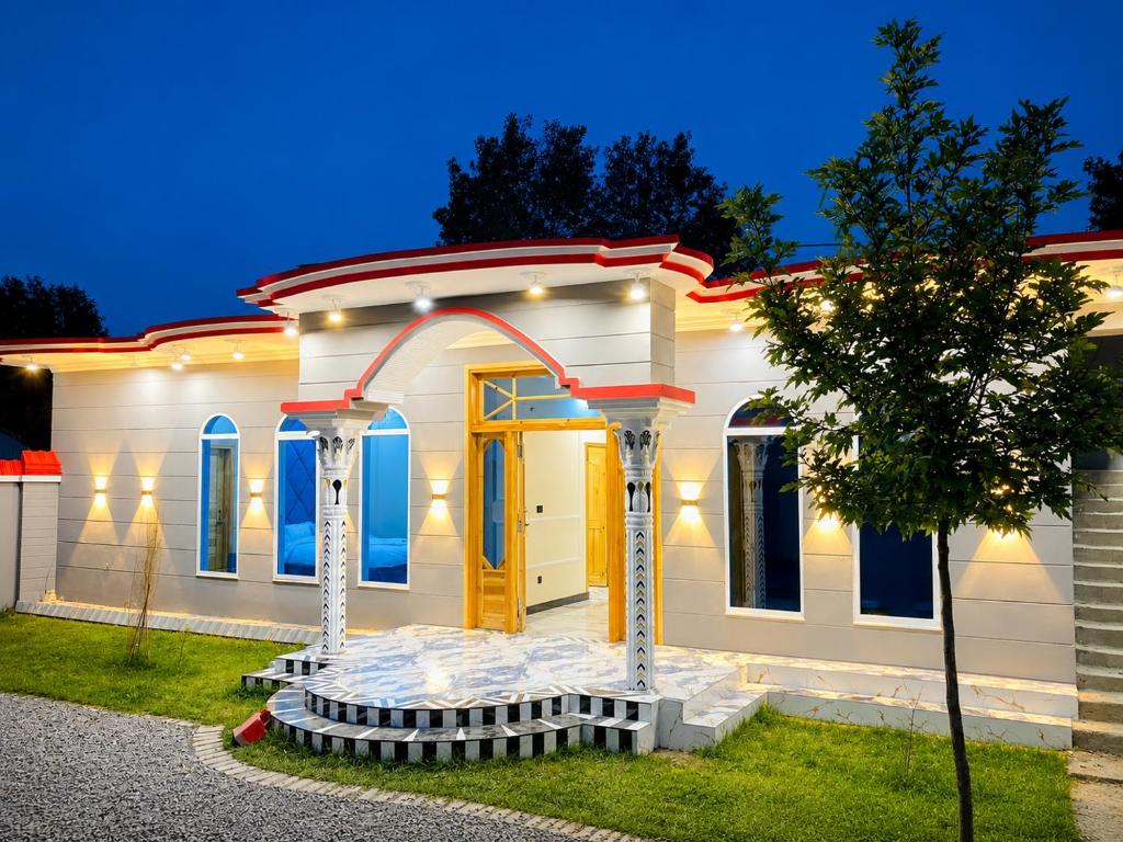 a white house with a yellow door in front at Nathia Gali Top Resort in Nathia Gali