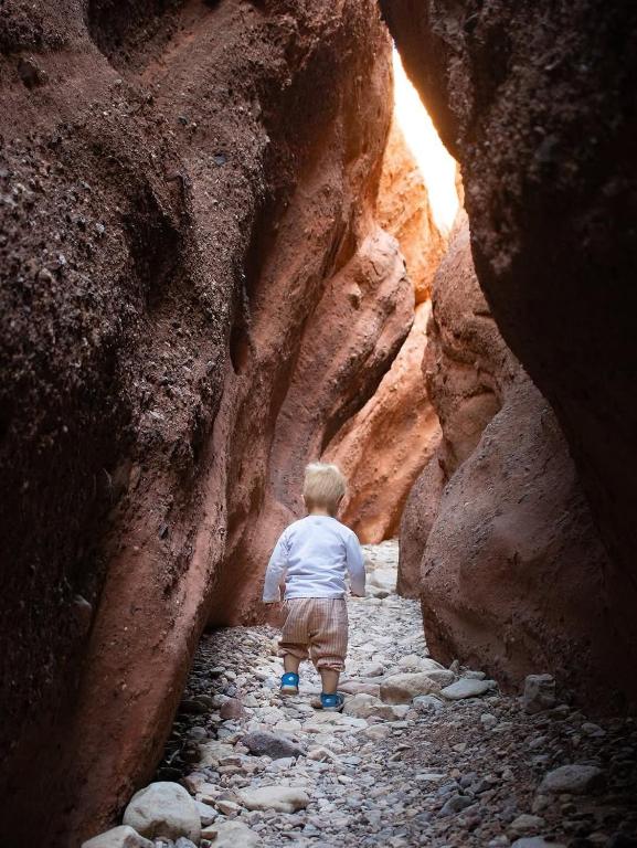 a young boy walking through a rock cave at Hotel restaurant ait saderat in Boumalne Dades