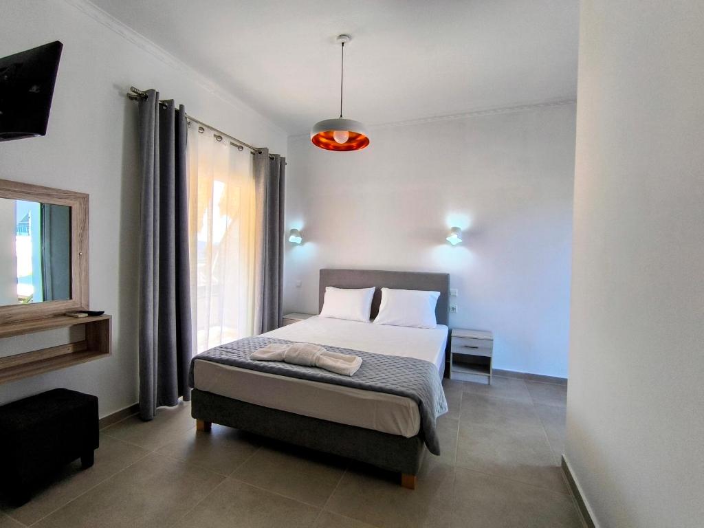 a bedroom with a bed and a window at Ioannis Fotinos Rooms in Lygia