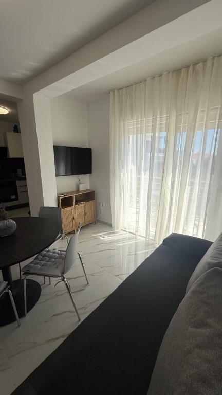 a bedroom with a bed and a table and a television at Apartman Pijuk in Slatine