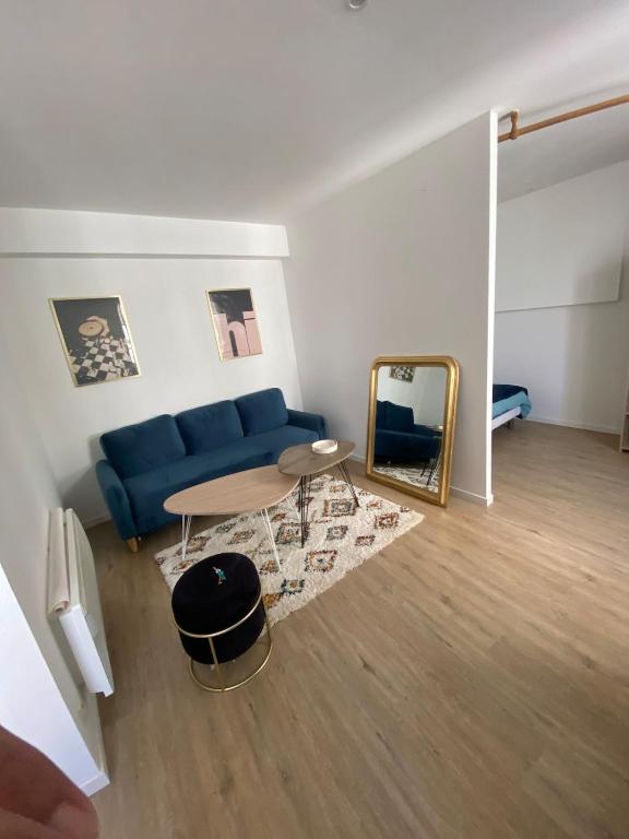a living room with a blue couch and a mirror at Halles in Les Sables-d'Olonne