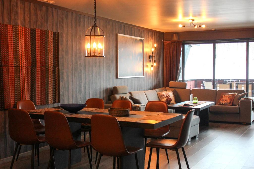 a dining room with a table and a couch at Stølstunets samlingssted in Beitostøl