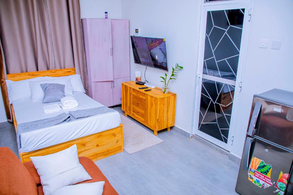 a small bedroom with a bed and a tv at ExtraMile Apartments - Cozy Studio in Dodoma