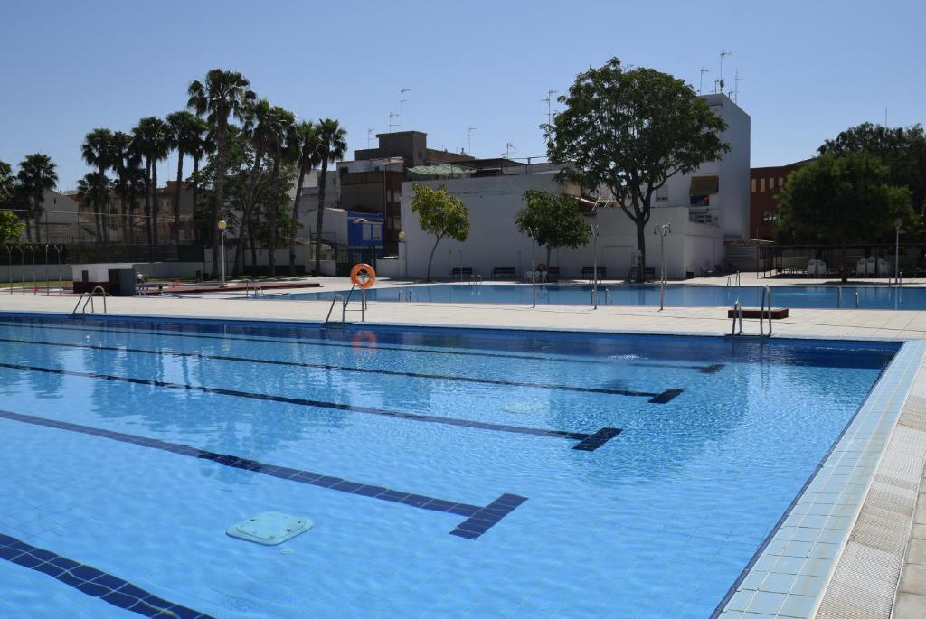 a large swimming pool with blue water at Hotel Antequera Rural Fortes La Nuit in Mollina
