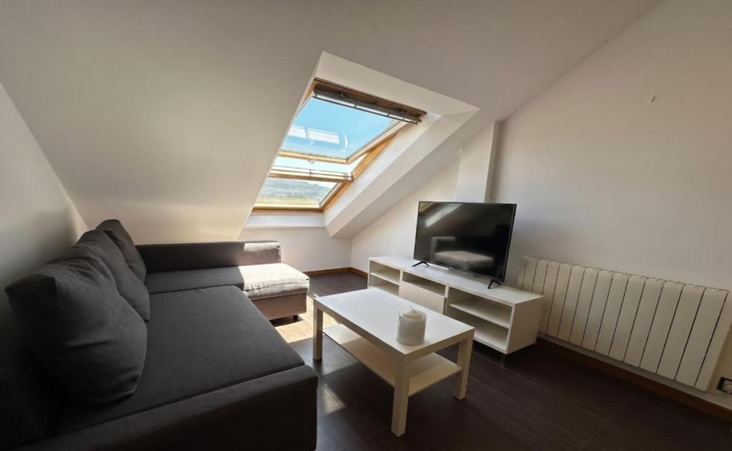 a living room with a couch and a tv at Playa America 4F by YBH in Nigrán