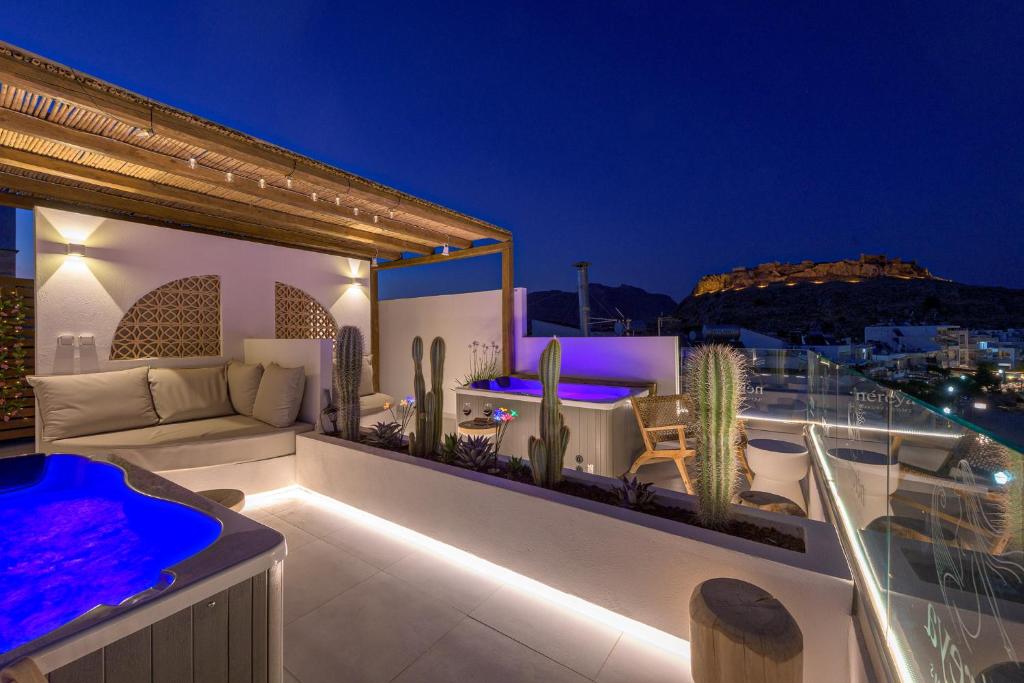eine Dachterrasse mit Sofa und Kakteen auf einem Dach in der Unterkunft néreya luxury rooms in Charaki