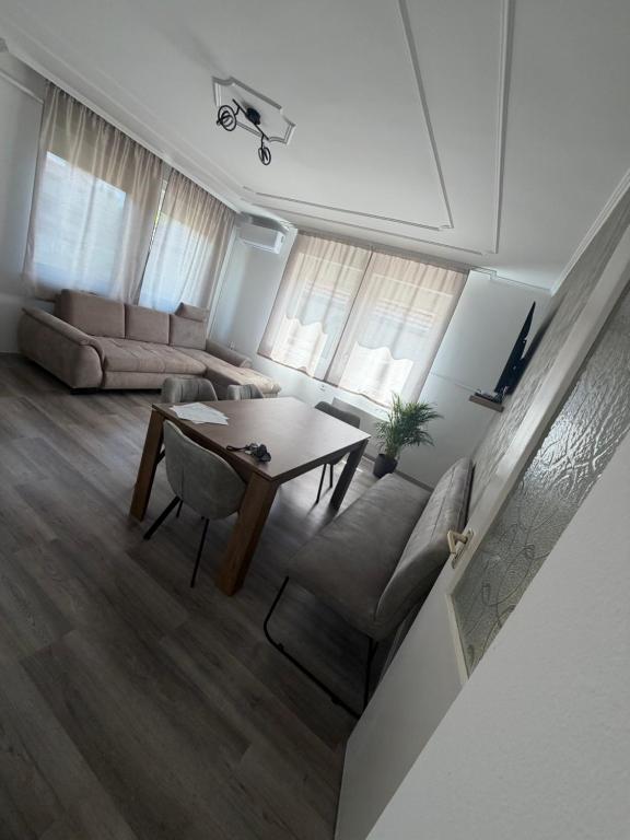 a living room with a table and a couch at Ide Vissza apartman 3 in Siófok