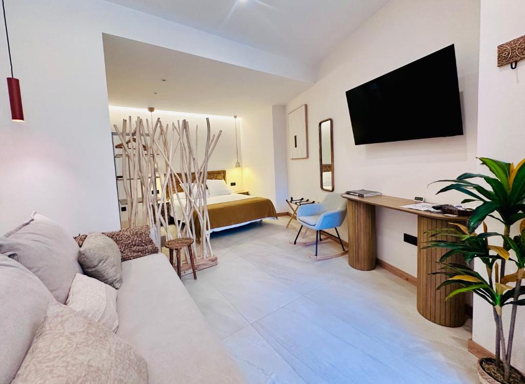 ein Wohnzimmer mit einer Couch und einem Fernseher an der Wand in der Unterkunft Alpha Estudios, Apartamentos turísticos in Astorga
