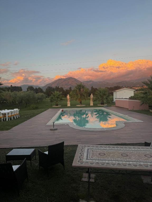 a view of a pool with a sunset in the background at Villa Ursino in Scalea