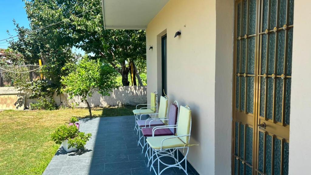 eine Reihe Stühle auf einer Terrasse in der Unterkunft Lin Luli in (( Shën Ded Gjoni ))