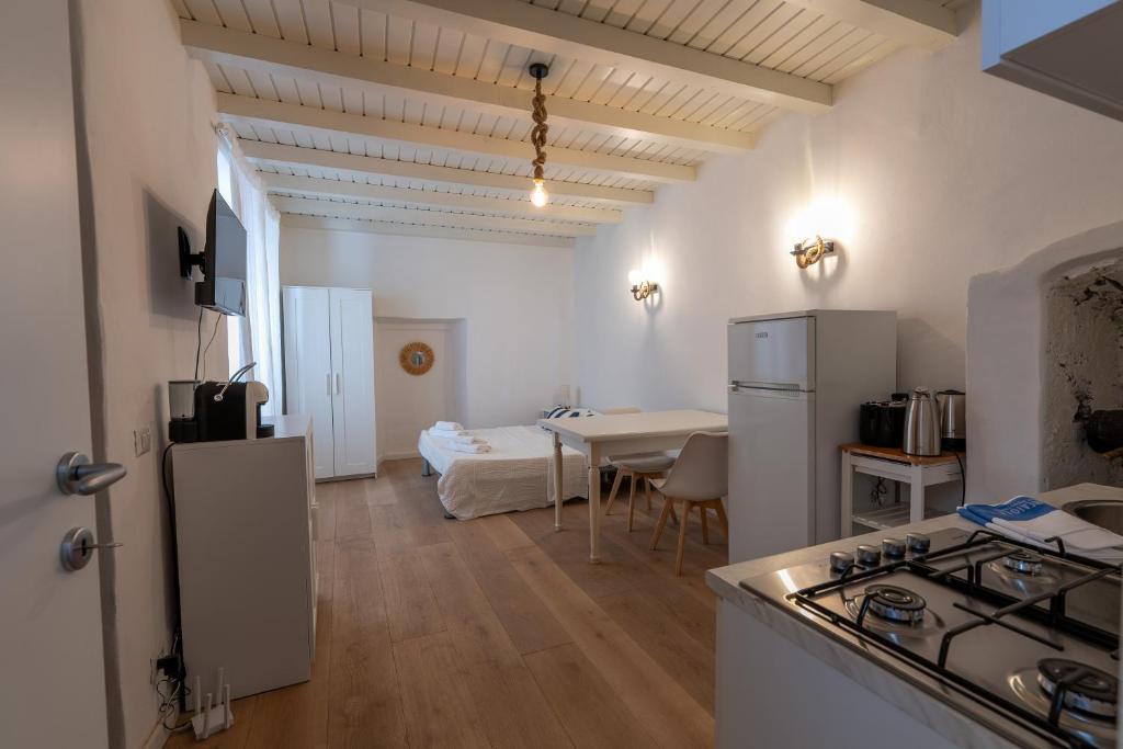 eine Küche und ein Wohnzimmer mit Tisch und Kühlschrank in der Unterkunft Breva e Tivano in Rezzonico