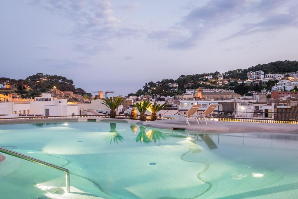 a swimming pool with a view of a city at Hotel Delfín 4 Sup in Tossa de Mar