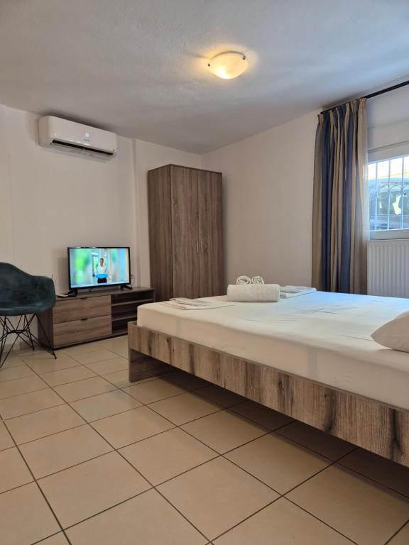 a bedroom with a large bed and a flat screen tv at Blue studio in Kavála