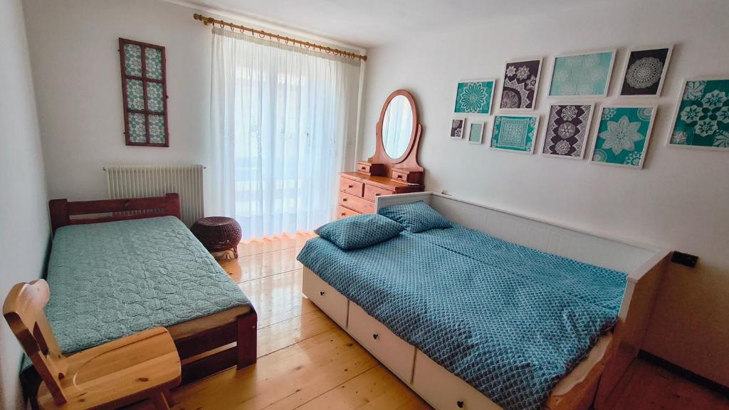 a bedroom with two beds and a mirror at Casa Pal Piccolo - Apartment with garage for bikes and fast wifi in Paluzza