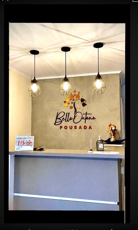 a counter with lights and a sign on a wall at Pousada Bello Outono in Canela