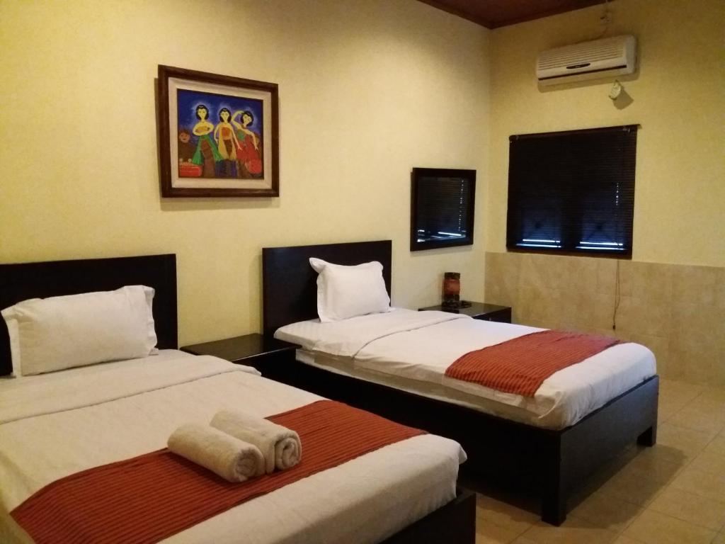 Postel nebo postele na pokoji v ubytování Alam Jogja Resort Mitra RedDoorz
